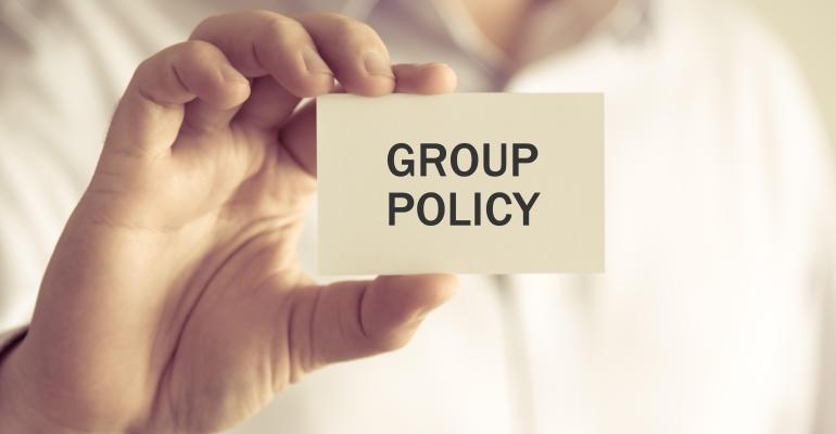 Closeup on businessman holding a card with text GROUP POLICY