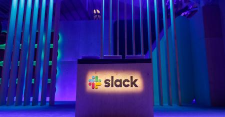A Slack logo is illuminated on a conference stage at Slack Frontiers 2019