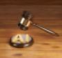 Wooden gavel with brass engraving band and golden alphabets AI on a round wood sound block